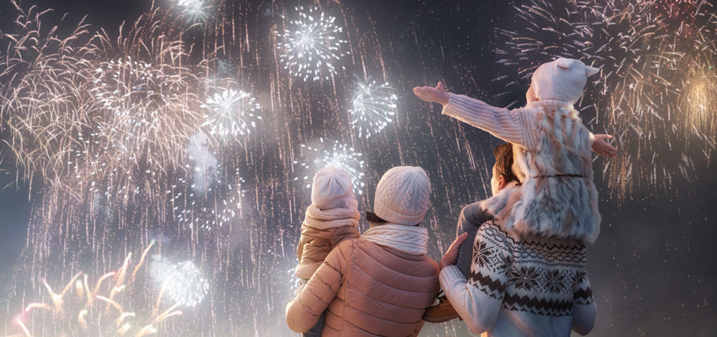 Kinder schauen mit ihren Eltern Feuerwerk